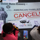 WASHINGTON, DC - DECEMBER 13: Children draw on top of a ‘canceled check’ prop during a rally in front of the U.S. Capitol on December 13, 2021, in Washington, DC.